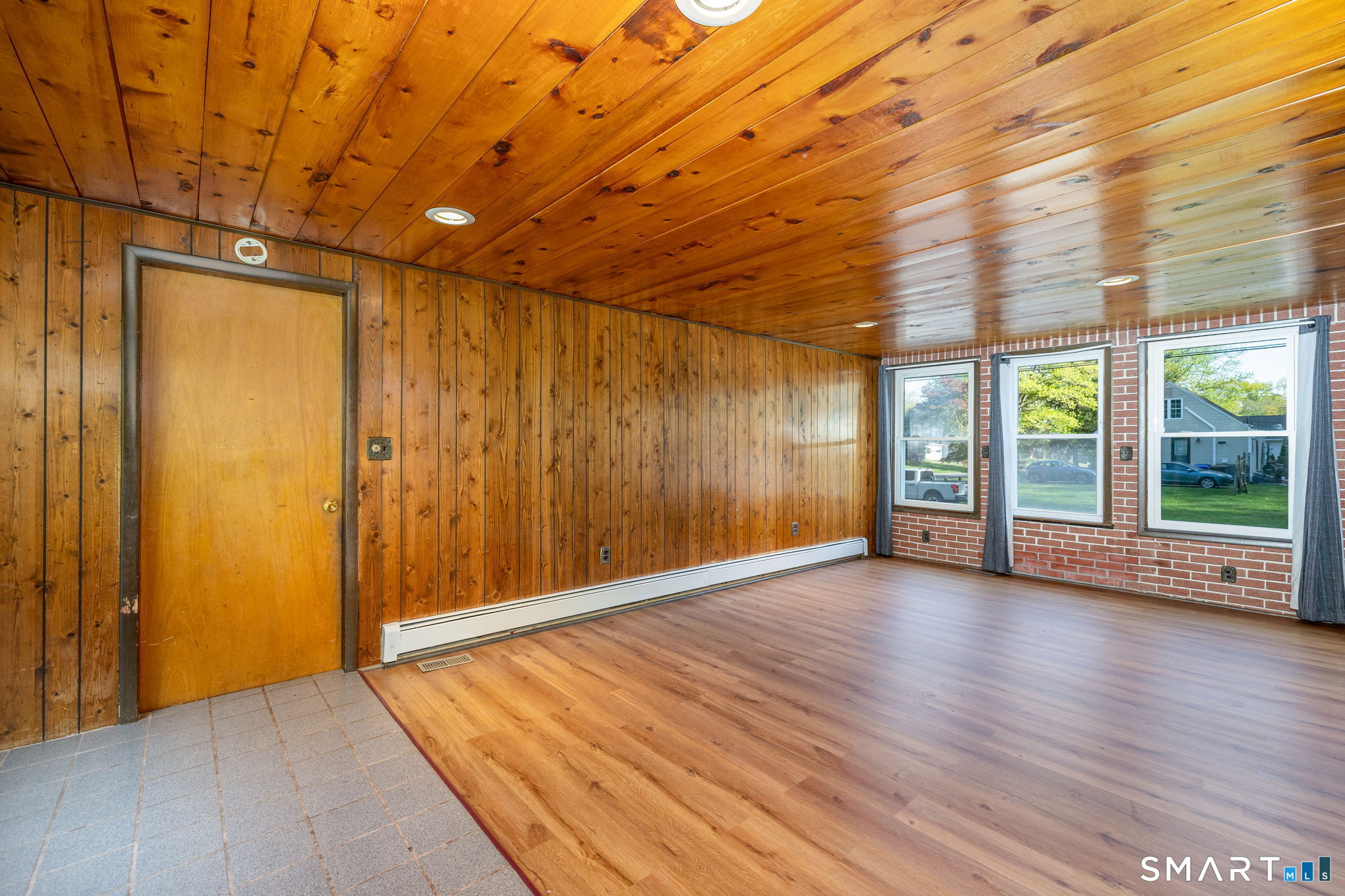 50 Brook Road Enfield, CT 06082 - Photo 13 of 34 an empty room with wooden floor and windows with curtains