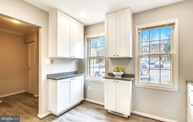 a kitchen with granite countertop white cabinets and white appliances