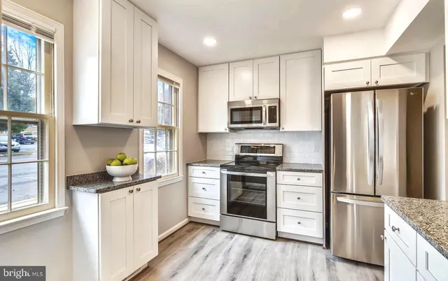 a kitchen with stainless steel appliances a refrigerator sink and cabinets
