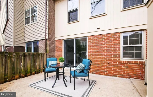 a patio with table and chairs and potted plants