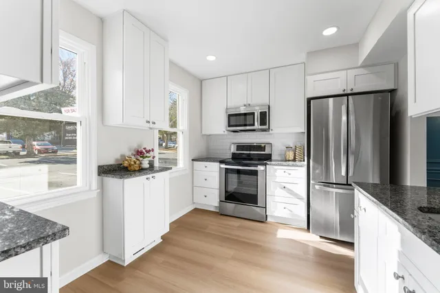 a kitchen with granite countertop a refrigerator and a sink