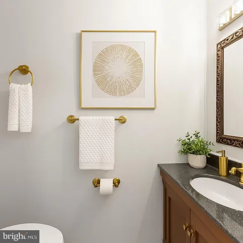 a bathroom with a granite countertop sink a toilet and a mirror