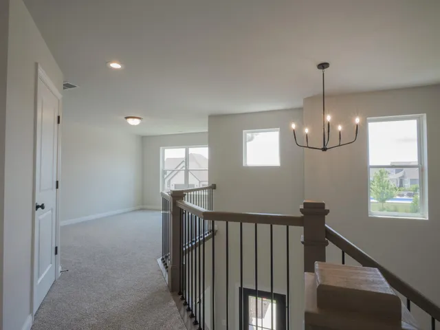 a view of hallway with windows and chandelier