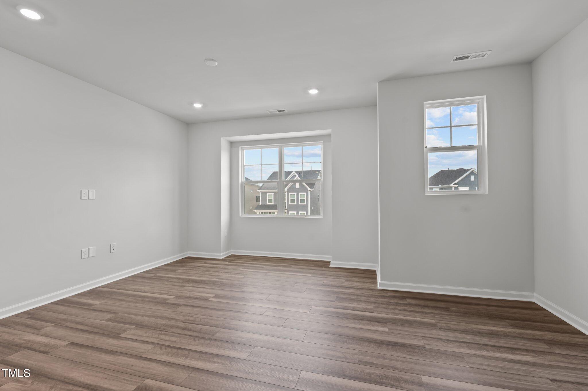 Undisclosed Address Wake Forest, NC 27587 - Photo 12 of 35 a view of an empty room with wooden floor and a window