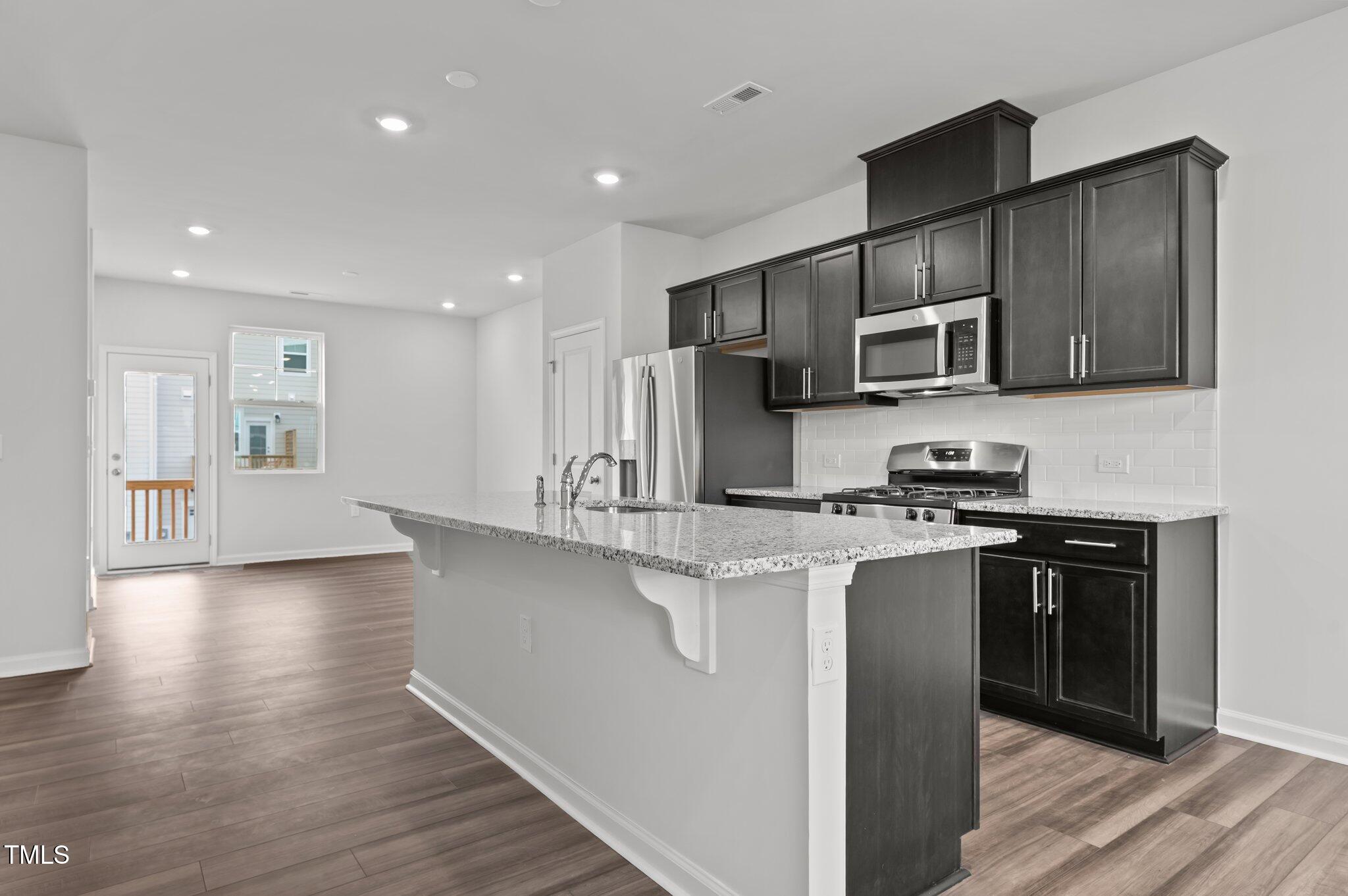Undisclosed Address Wake Forest, NC 27587 - Photo 13 of 35 a kitchen with stainless steel appliances a sink stove and refrigerator