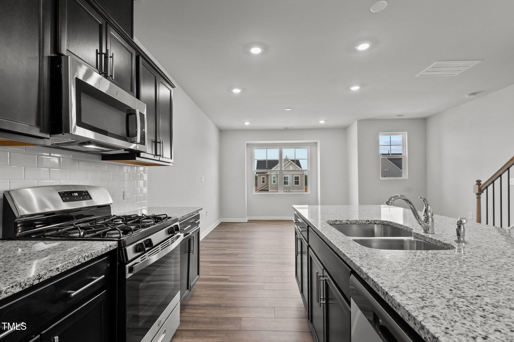 Undisclosed Address Wake Forest, NC 27587 - Photo 14 of 35 a kitchen with stainless steel appliances granite countertop a sink and stove top oven