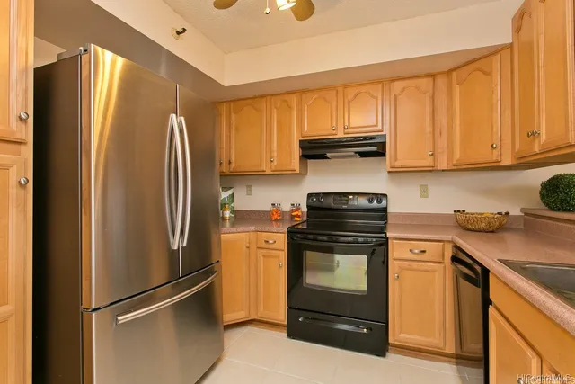 a kitchen with stainless steel appliances granite countertop a refrigerator stove and sink