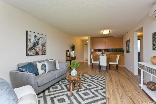 a living room with furniture and a dining table with kitchen view