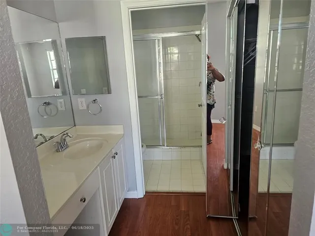 a bathroom with a granite countertop sink mirror and shower