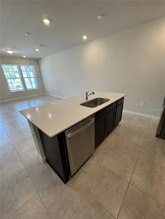 a large kitchen with a large counter top stainless steel appliances and cabinets