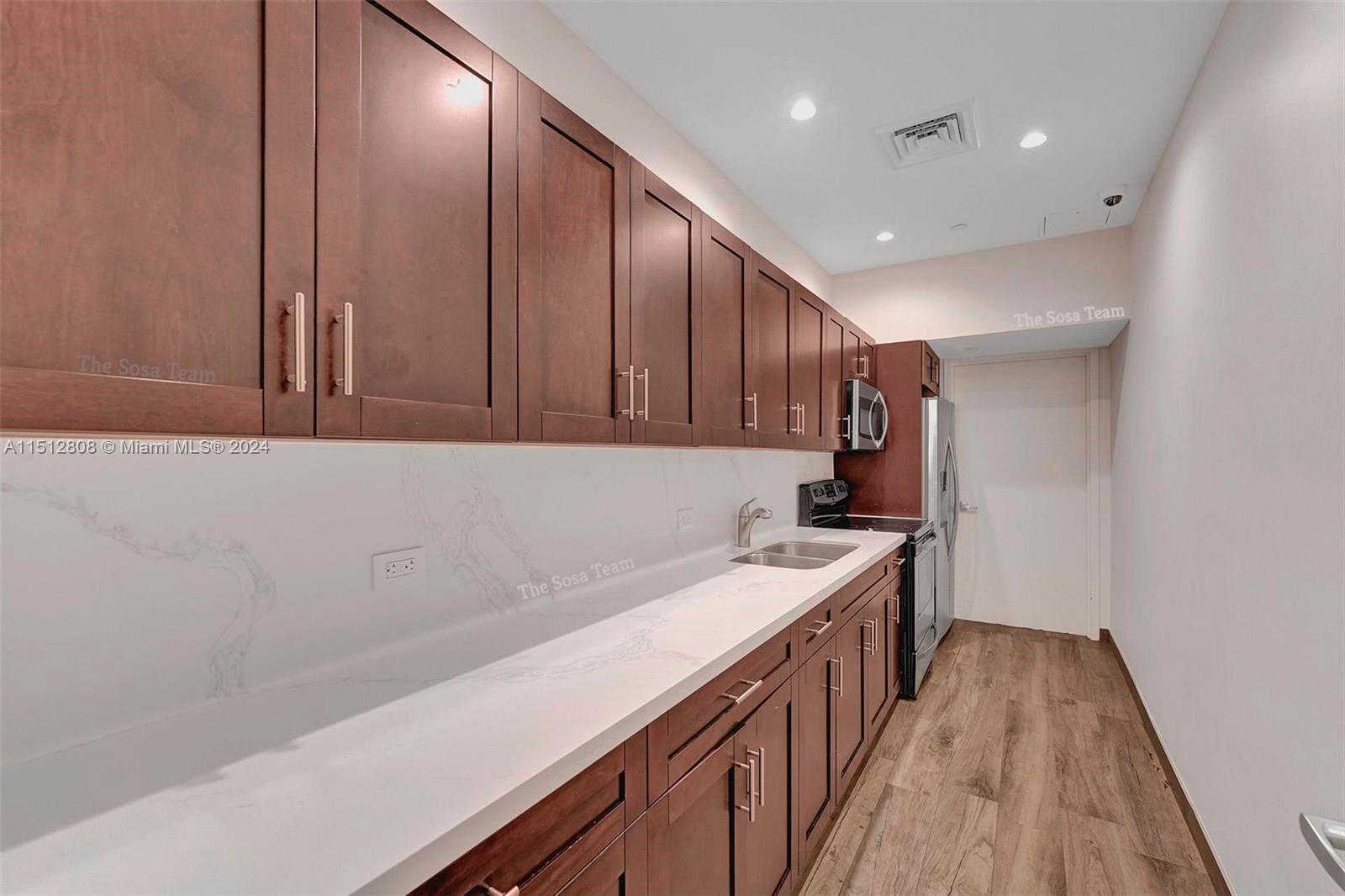 801 Brickell Key Boulevard, Unit 3004 Miami, FL 33131 - Photo 32 of 33 a kitchen with a sink and wooden floor