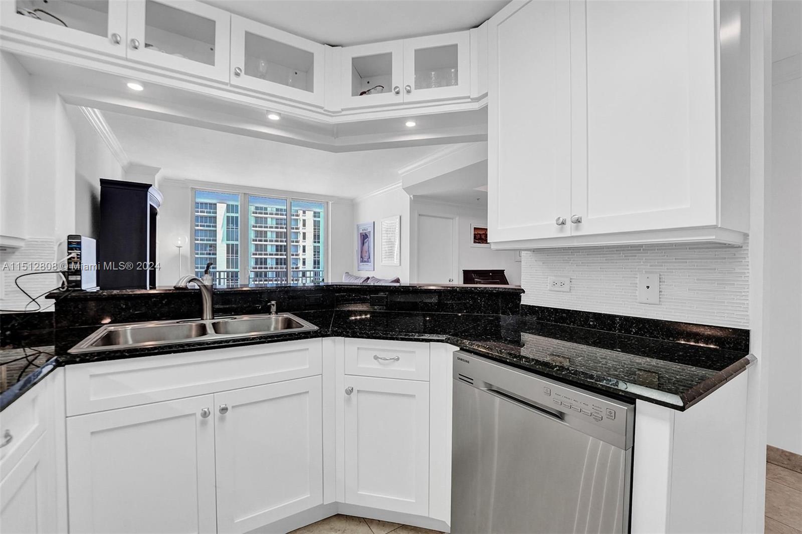 801 Brickell Key Boulevard, Unit 3004 Miami, FL 33131 - Photo 5 of 33 a kitchen with granite countertop a sink and cabinets