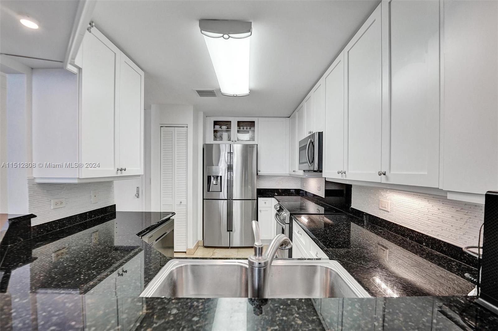 801 Brickell Key Boulevard, Unit 3004 Miami, FL 33131 - Photo 7 of 33 a kitchen with stainless steel appliances granite countertop a sink stove and refrigerator