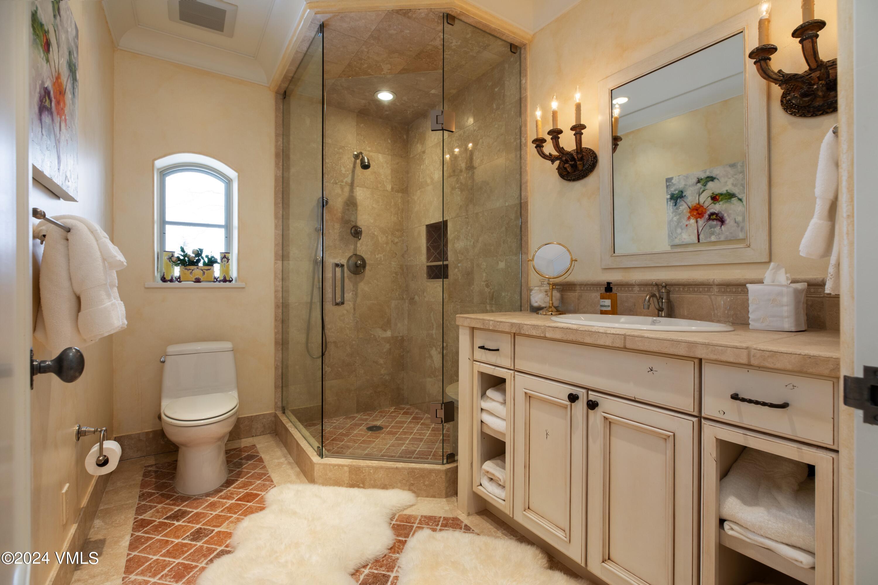 44 Jasmine Avon, CO 81620 - Photo 25 of 41 a bathroom with a granite countertop sink a toilet a mirror and shower