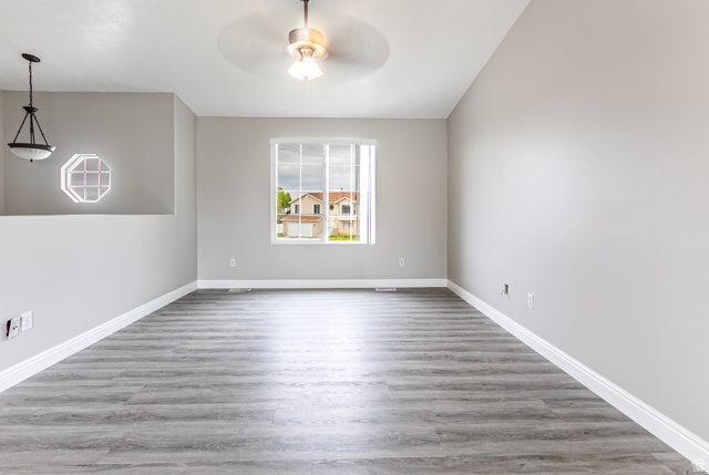 4239 West 5325th Street South Roy, UT 84067 - Photo 4 of 26 Spacious room featuring wood-finish flooring, light gray walls, and white trim