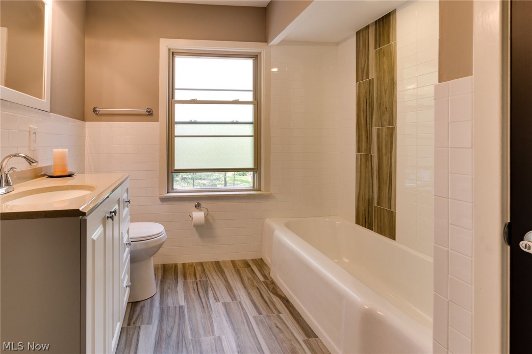 1046 Allston Road Cleveland Heights, OH 44121 - Photo 26 of 34 The main bathroom has a large linen closet, new vanity, top and faucet, new toilet, all new ceramic subway tile on the walls and tub surround, and wood grained ceramic floor tile.