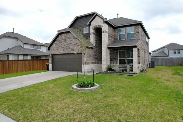 a front view of a house with a garden and yard
