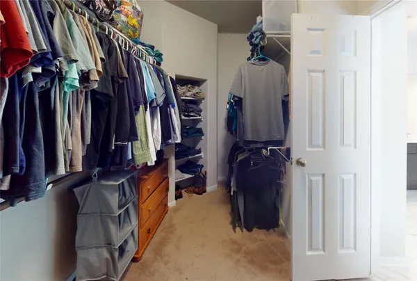 a view of walk in closet with clothes