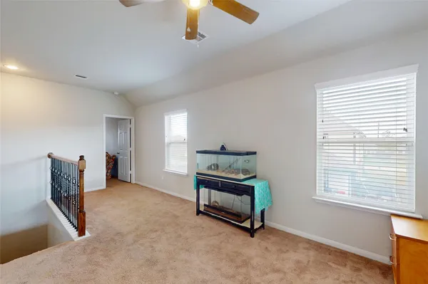 an empty room with windows and fan