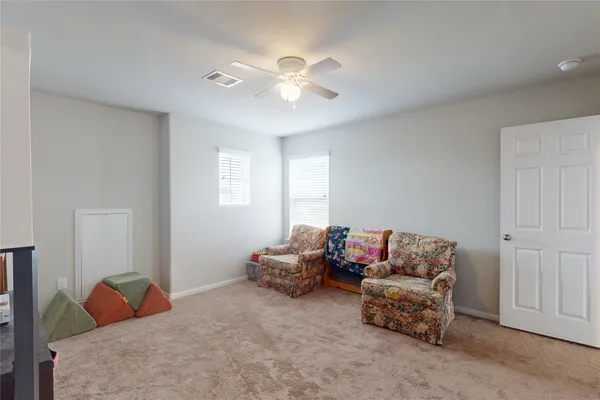 a living room with furniture and a ceiling fan