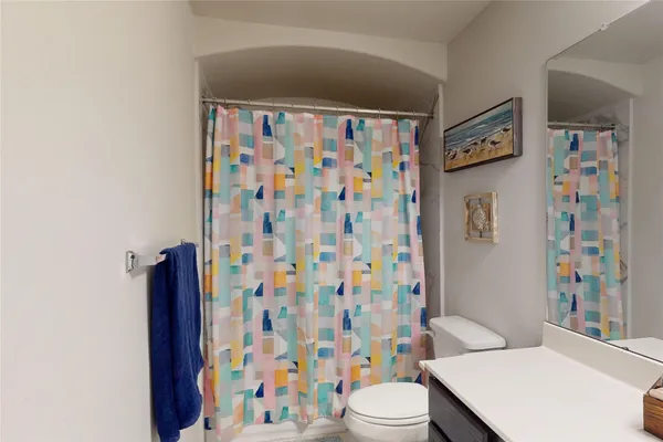 a white toilet sitting next to a shower curtain