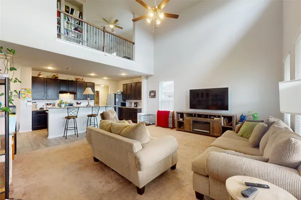 a living room with furniture kitchen view and a flat screen tv