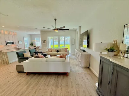 a kitchen with a sink stove cabinets and wooden floor