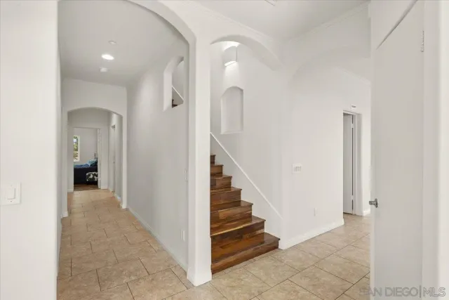 an empty room with wooden floor and entrance