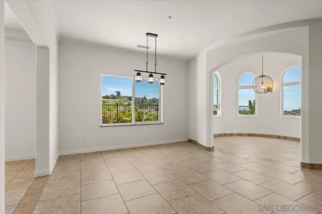 an empty room with windows and chandelier