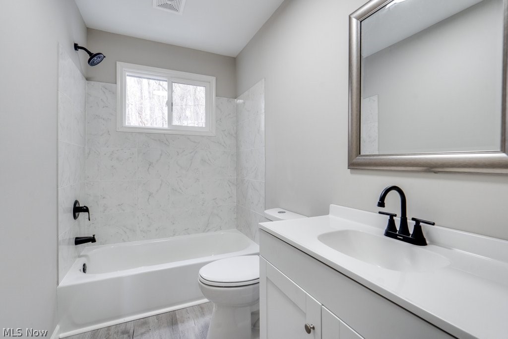 4596 Hattrick Road Rootstown, OH 44272 - Photo 24 of 45 Full bathroom with hardwood / wood-style floors, tiled shower / bath, toilet, and vanity with extensive cabinet space