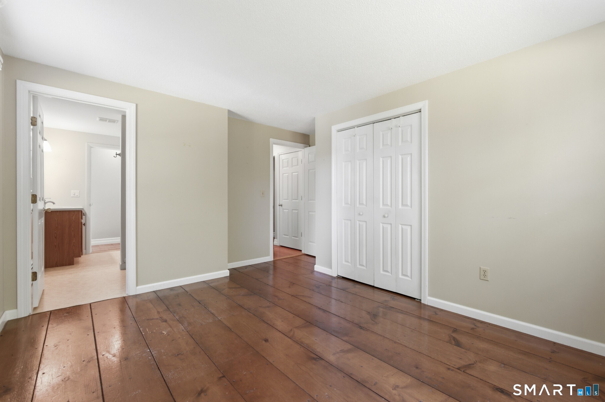 70 Mahoney Road Colchester, CT 06415 - Photo 16 of 40 an empty room with wooden floor and mirror