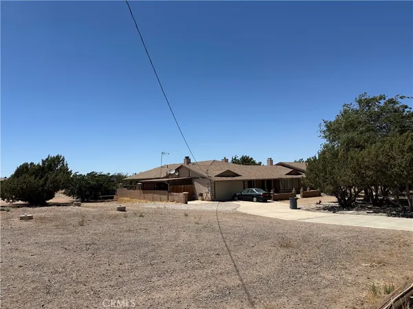 a view of house with outdoor space and trees in the background