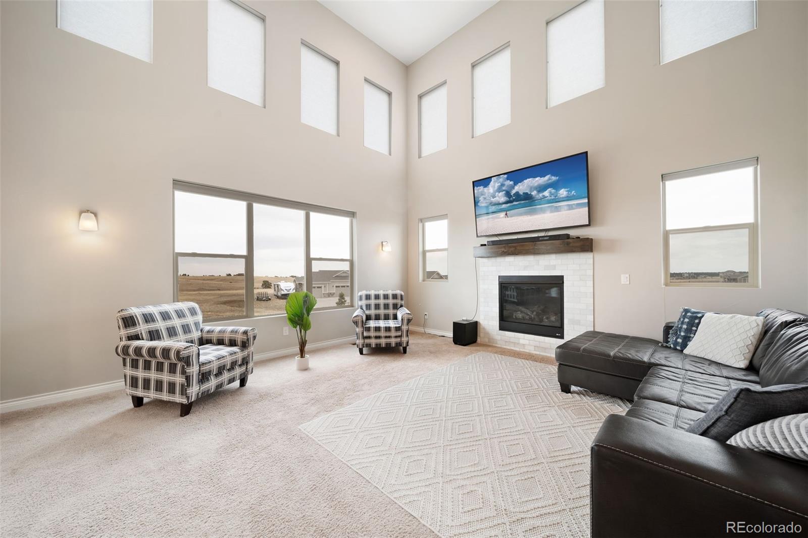 240 High Meadows Loop Elizabeth, CO 80107 - Photo 12 of 50 a living room with furniture a fireplace and a large window