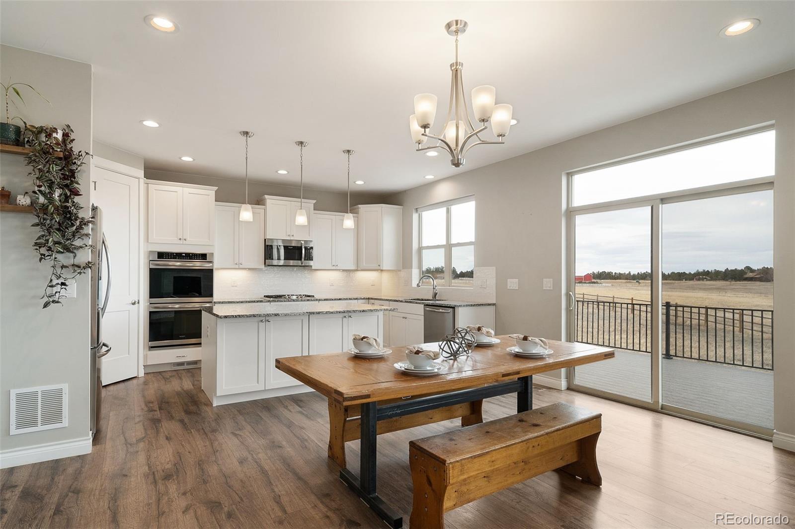 240 High Meadows Loop Elizabeth, CO 80107 - Photo 17 of 50 a view of a dining room and livingroom with furniture wooden floor a chandelier