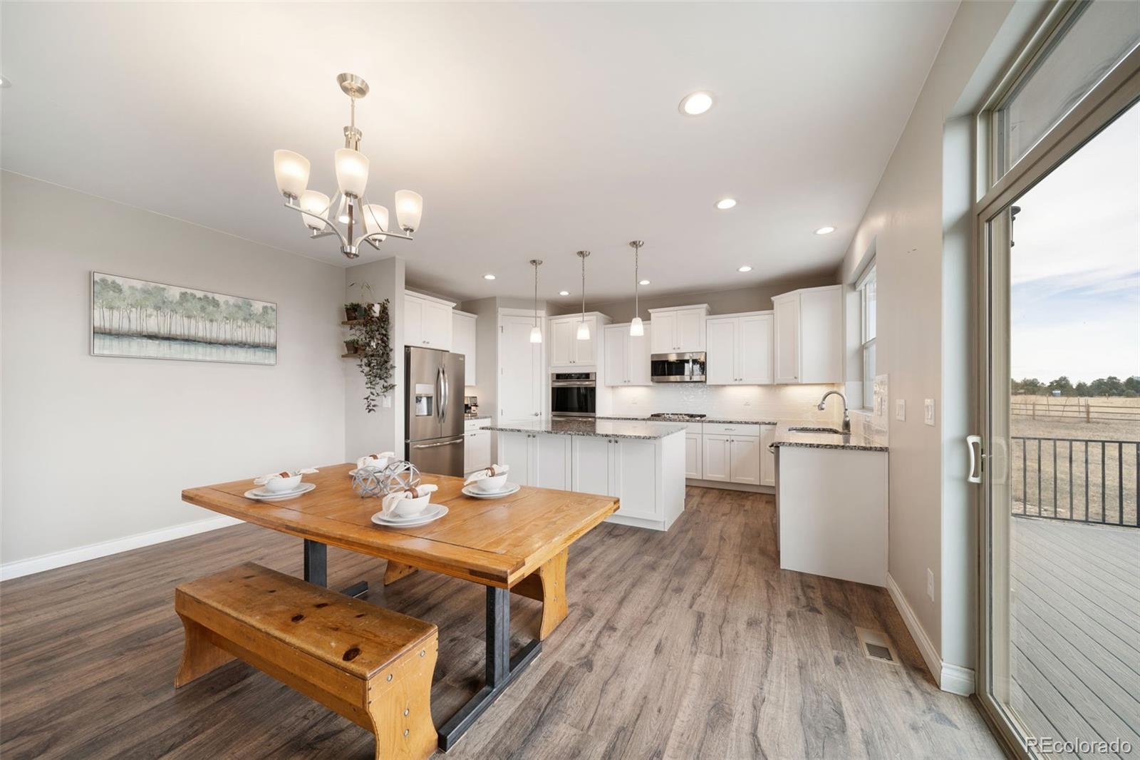 240 High Meadows Loop Elizabeth, CO 80107 - Photo 19 of 50 a open dining room with kitchen island stainless steel appliances furniture stove and wooden floor