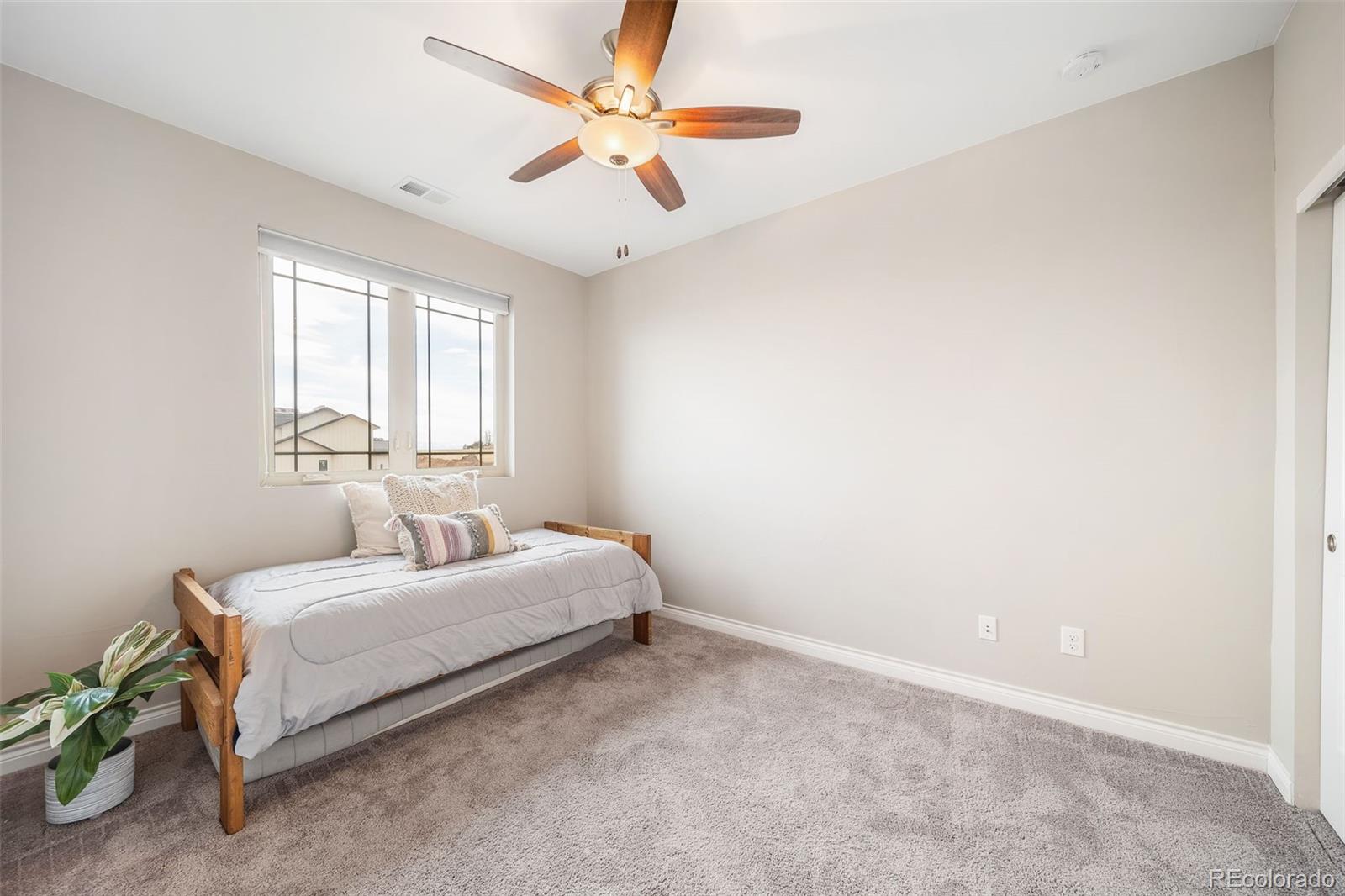 240 High Meadows Loop Elizabeth, CO 80107 - Photo 39 of 50 a bedroom with a bed and a ceiling fan