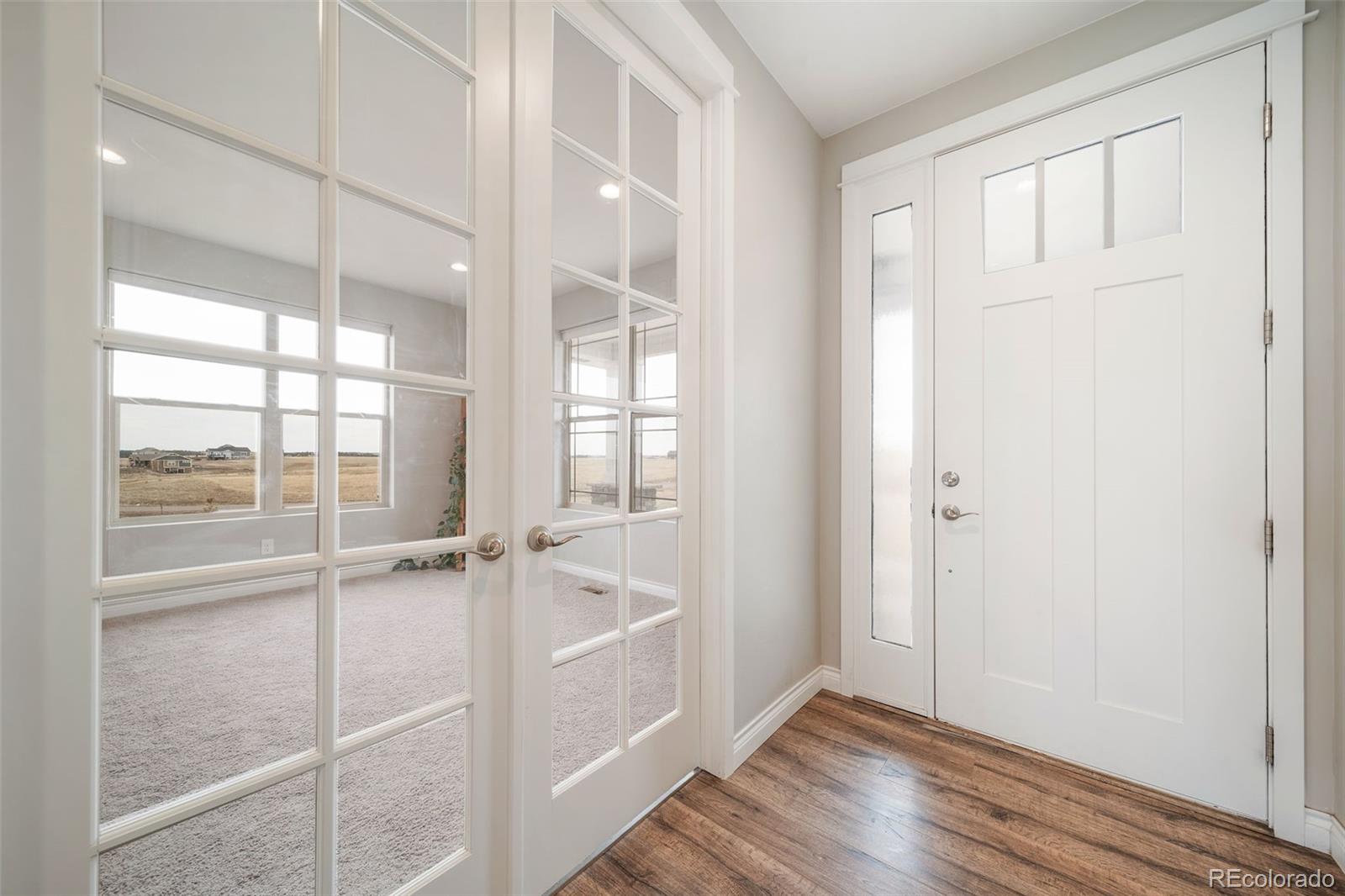 240 High Meadows Loop Elizabeth, CO 80107 - Photo 9 of 50 a view of an empty room with wooden floor and a window