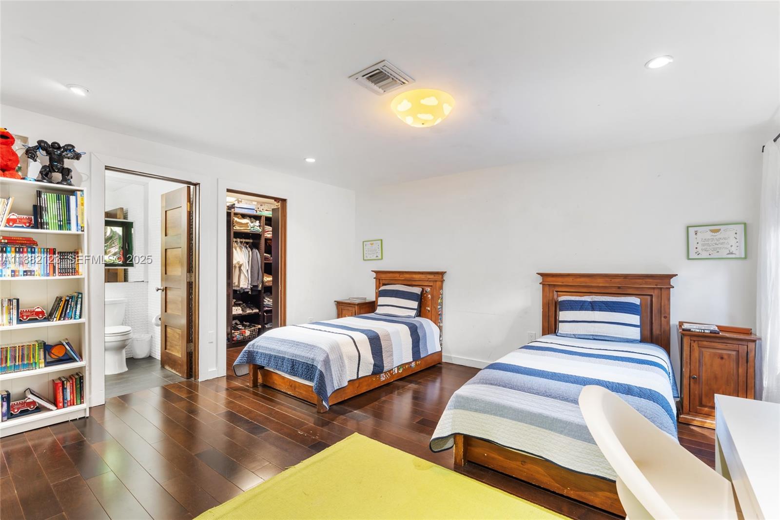 560 Sabal Palm Road Miami, FL 33137 - Photo 4 of 15 a bedroom with two beds and a book shelf