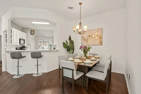 a view of a dining room with furniture wooden floor and chandelier
