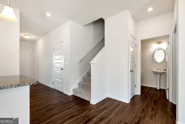 a view of a hallway with wooden floor and staircase