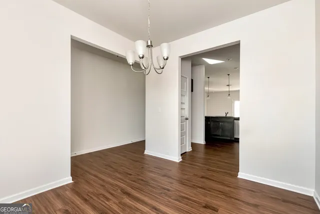 a view of a room with wooden floor staircase and a kitchen space