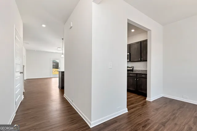 a view of a hallway with wooden floor and a living room