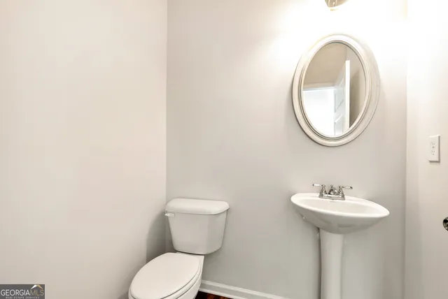 a bathroom with a toilet a sink and a mirror