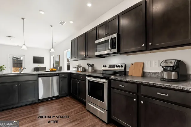 a kitchen with stainless steel appliances granite countertop a sink a stove top oven and wooden cabinets