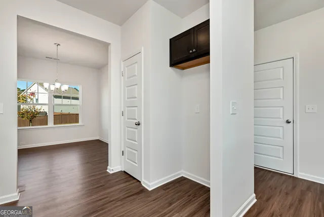a view of a hallway with wooden floor and a flat screen tv