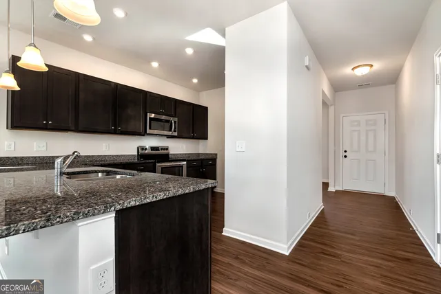 a kitchen with stainless steel appliances granite countertop a stove a sink and a granite counter top