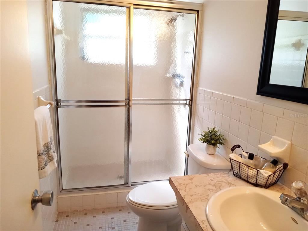 2427 Rhodesian Drive, Unit 11 Clearwater, FL 33763 - Photo 16 of 44 a bathroom with a granite countertop sink toilet and shower