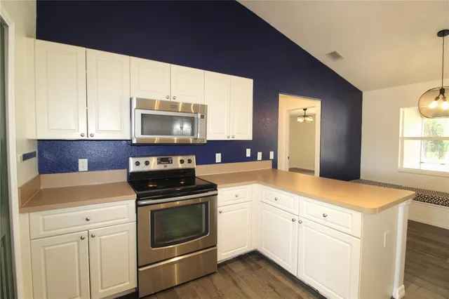 a kitchen with granite countertop white cabinets and appliances