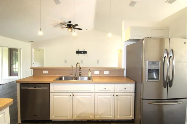 a kitchen with kitchen island a sink appliances and cabinets