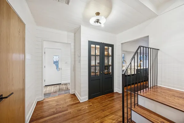 a view of a hallway with wooden floor and staircase
